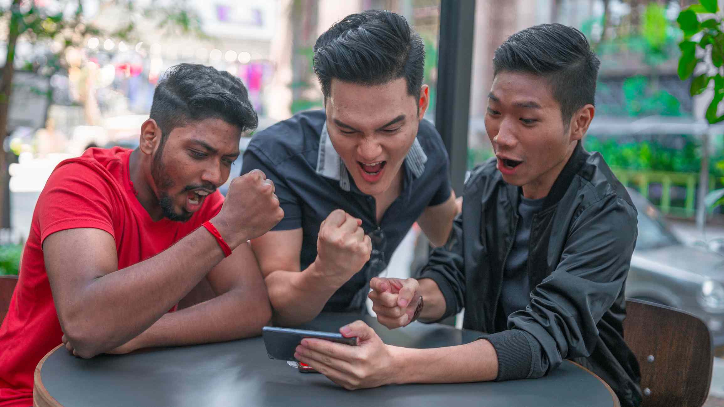 Group of friends playing mobile games on smartphone