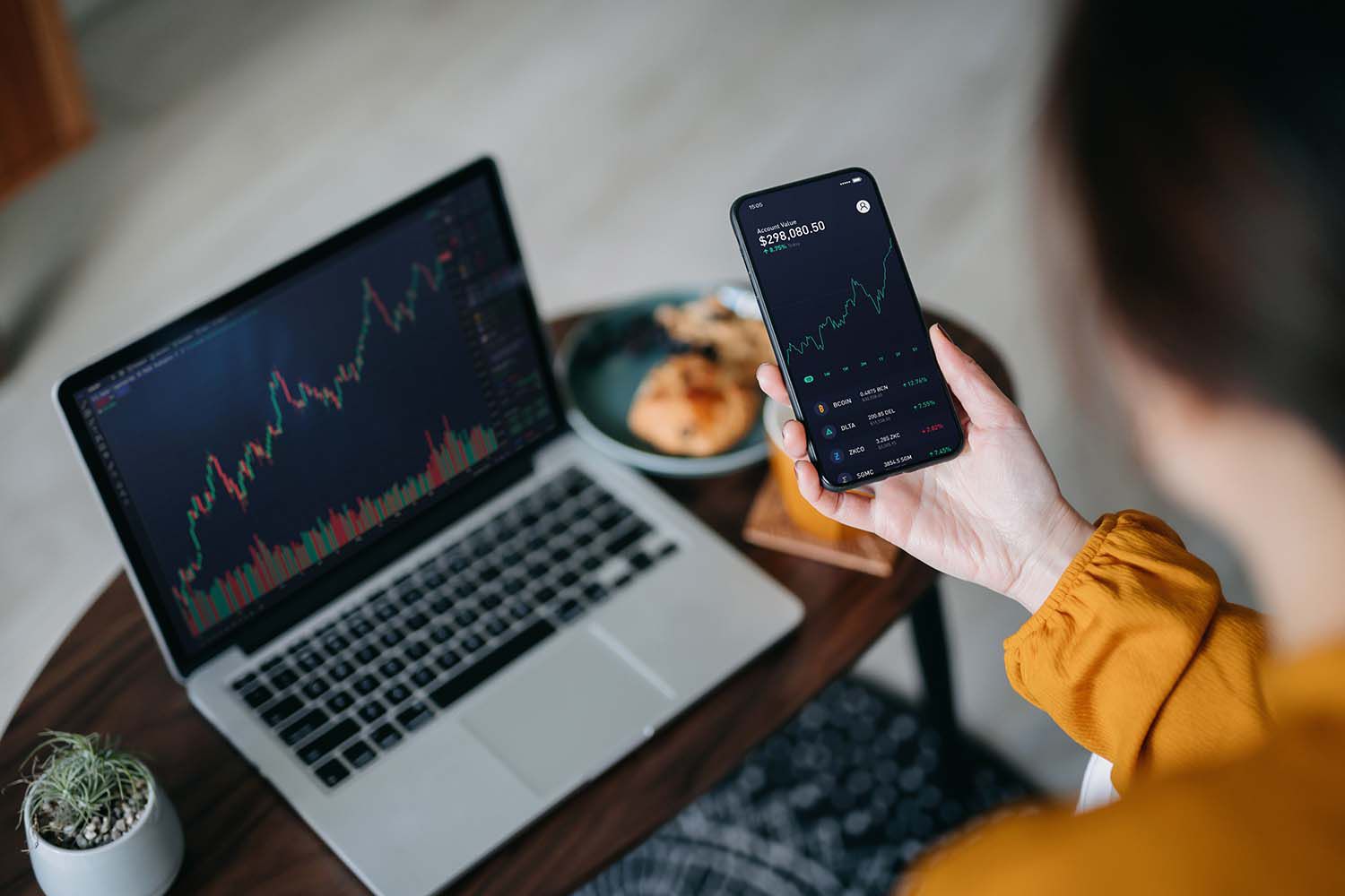 Woman Holds Smartphone, Analyzes Crypto Investment Trading Data